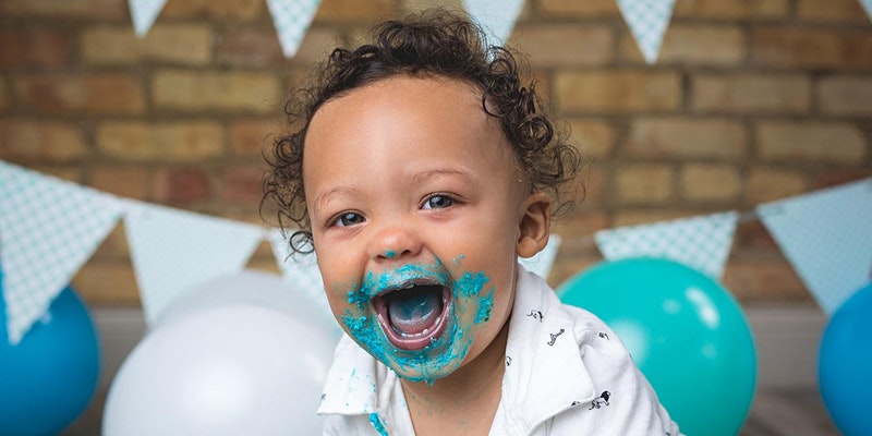 joyful child smiling during a smash cake photography session in a chicago photography studio
